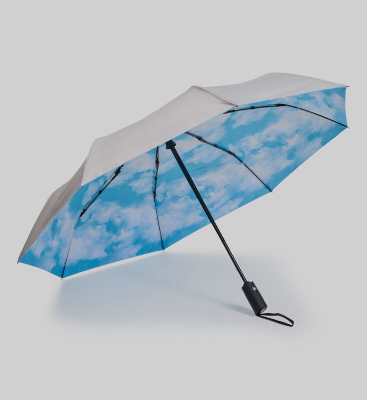 Umbrella with blue sky and cloud pattern on a light gray background