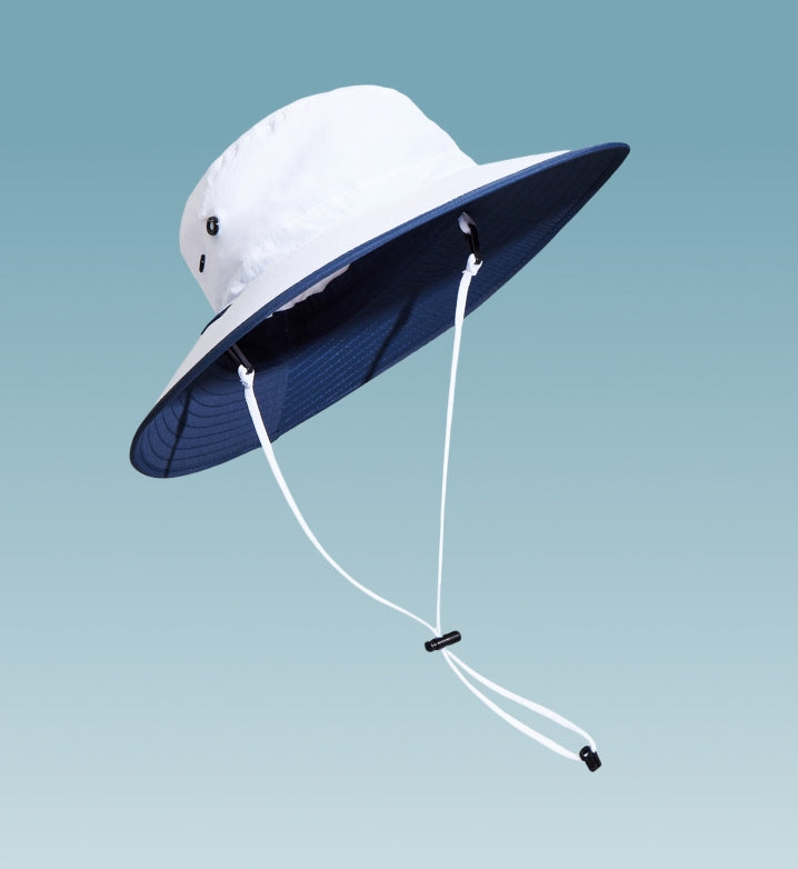 A white sun hat with a chin strap floating on a light blue background.